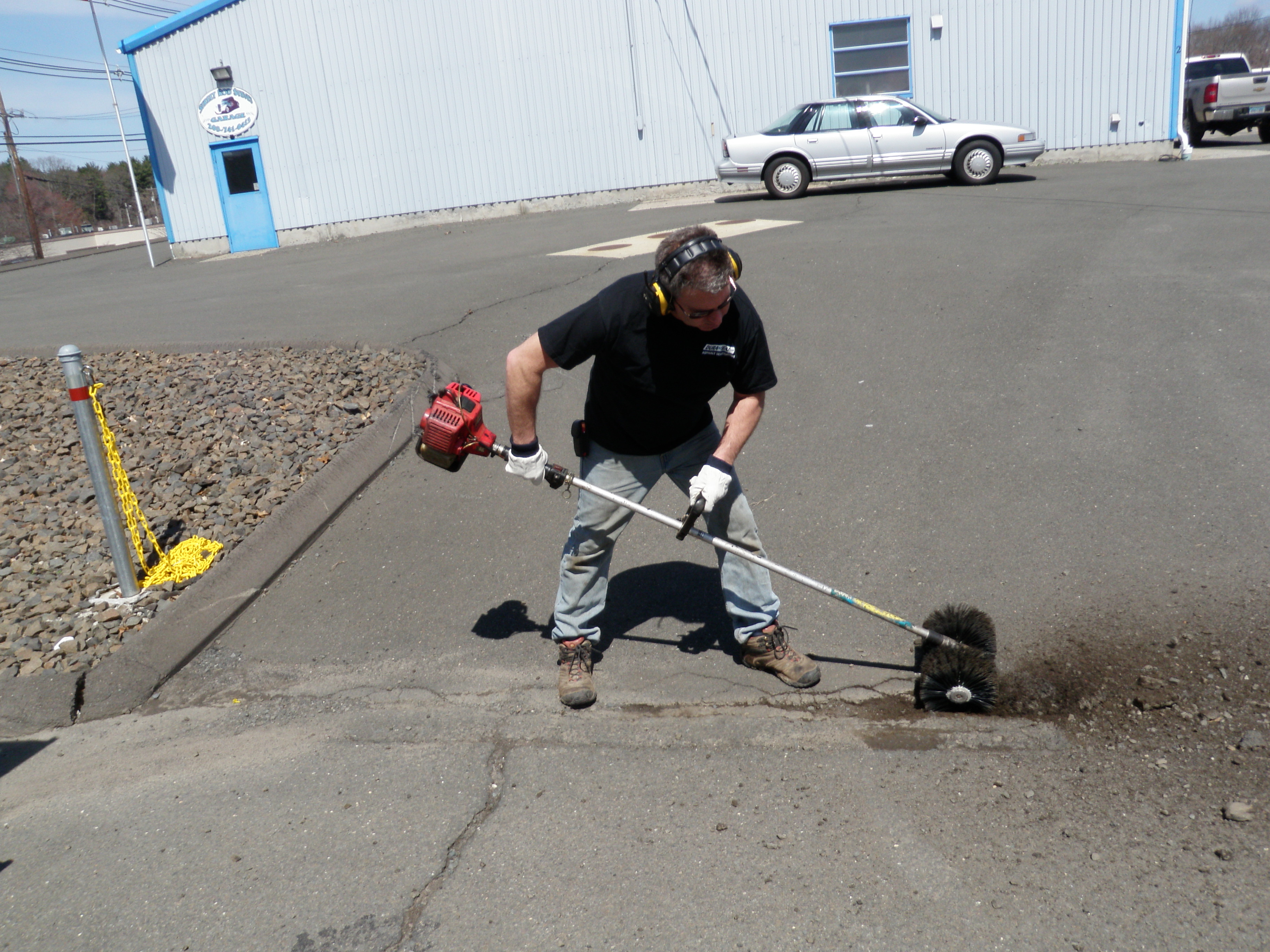 Cleaning Large Crack in Driveway with Power Brush